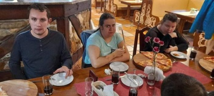 Uczniowie degustują pizzę włoską w restauracji.