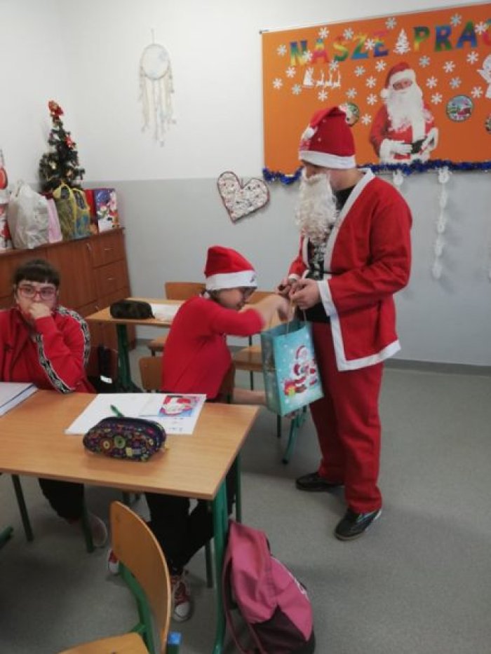 Mikołaj częstuje uczniów cukierkami.