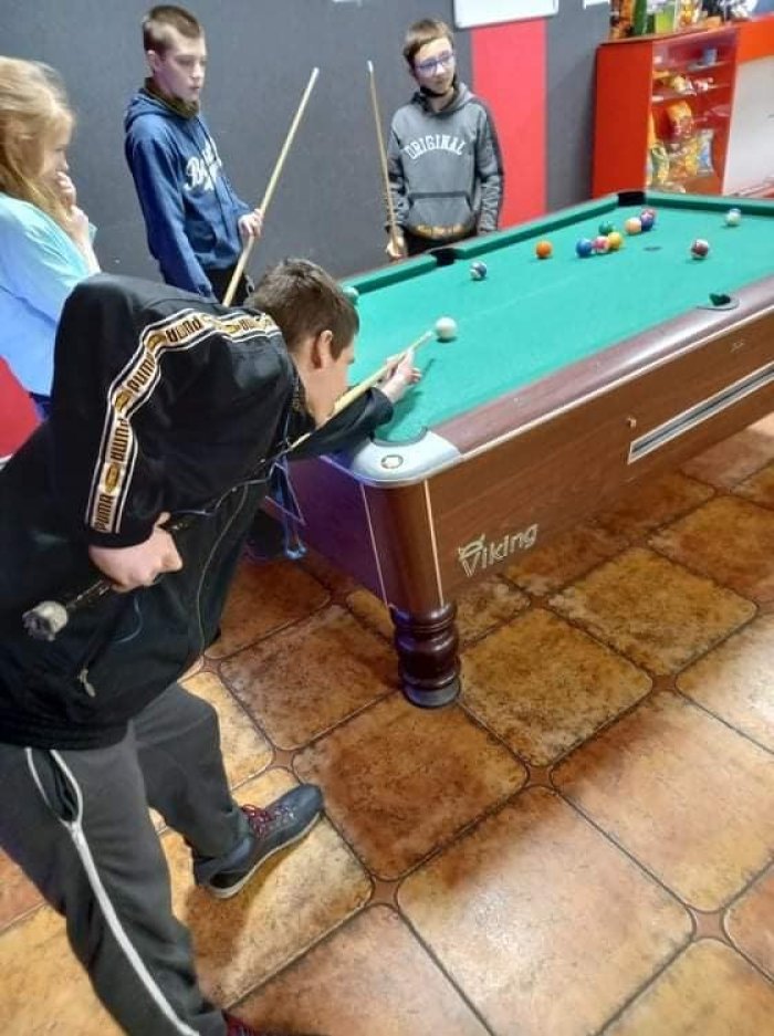 Uczniowie grają w bilarda. 