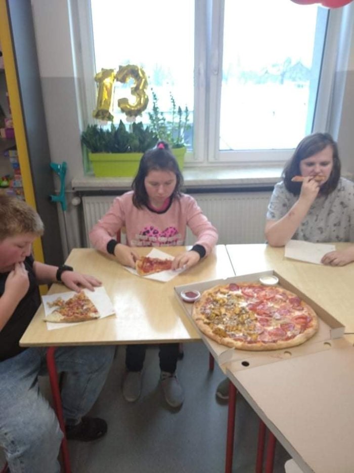 Uczniowie zjadają pyszną pizzę. 