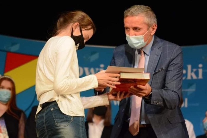 Uczennica otrzymuje nagrodę. 