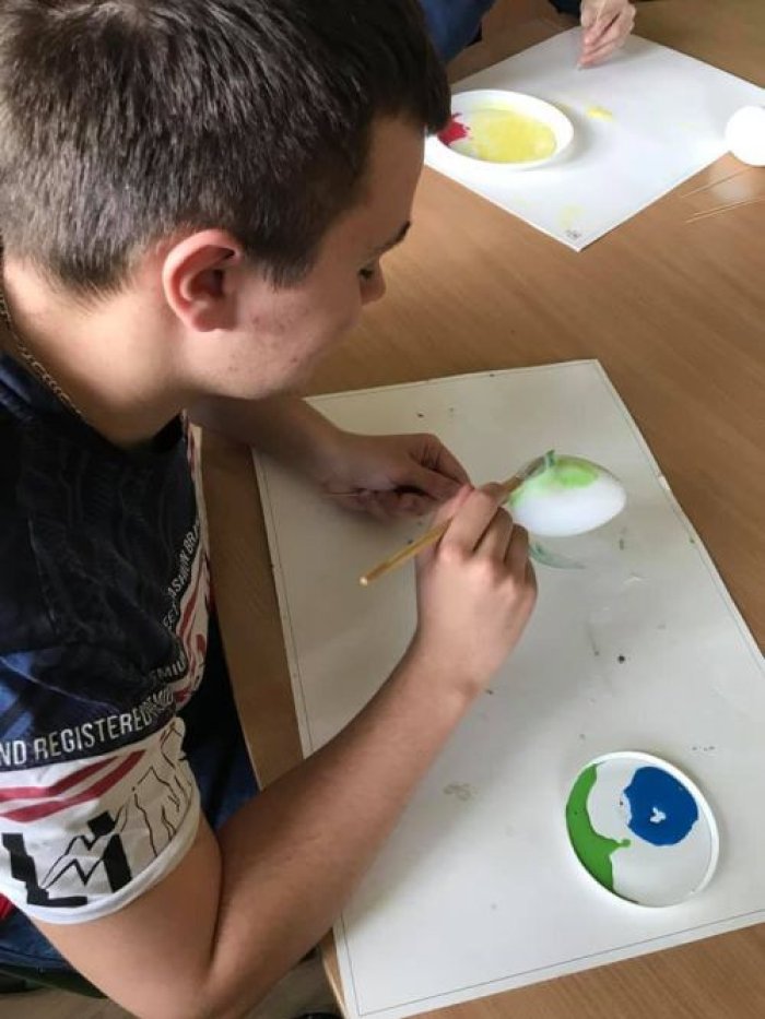 Uczeń klasy 2Pb wykonuje pisankę metodą decoupage