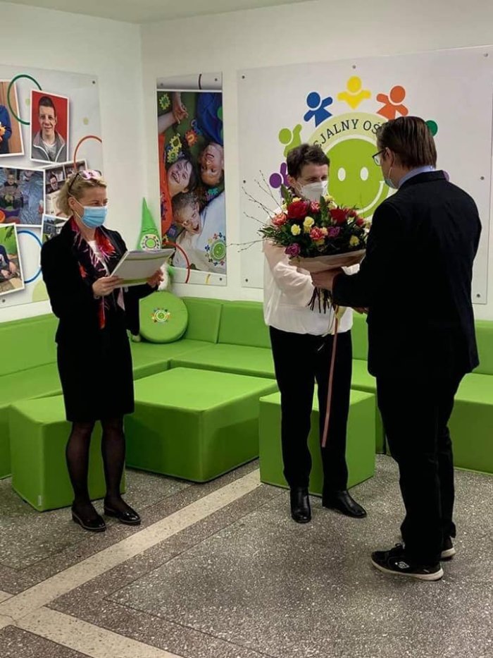Przedstawiciel Rady Pedagogicznej wręcza emerytce bukiet kwiatów