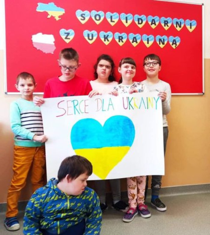 Uczniowie prezentują wykonaną wspólnie pracę plastyczną.