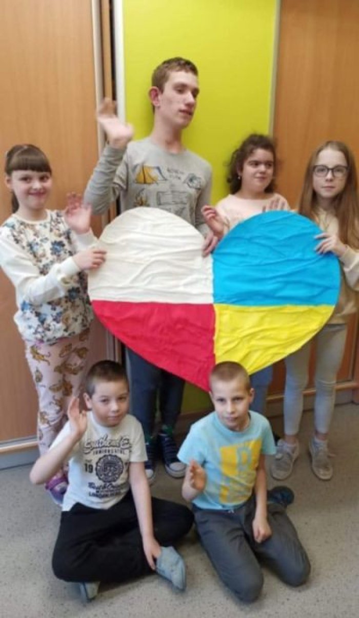 Wychowankowie świetlicy prezentują wykonane przez siebie serce dla Ukrainy.