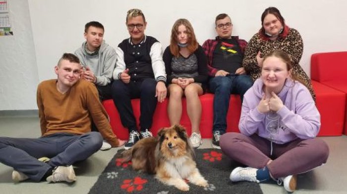 Uczniowie pozują do zdjęcia z psem terapeutycznym Kerrią.