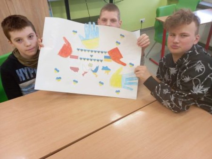 Uczniowie prezentują wykonany plakat o Ukrainie.