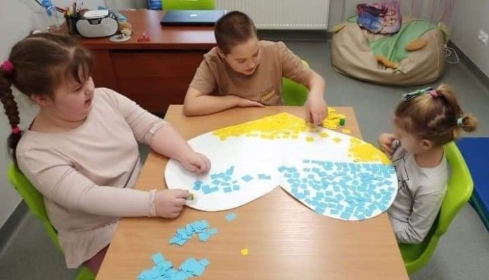 Uczniowie wykonują serce w ramach solidarności z Ukrainą. 