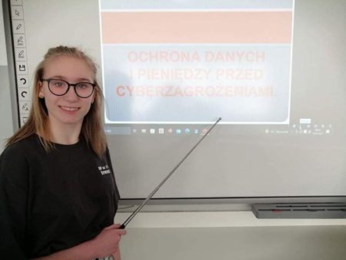 Uczennica klasy ósmej prowadzi warsztat dotyczący bezpieczeństwa finansów osobistych.