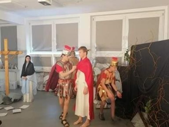 Uczniowie przedstawiają jak żołnierze zdzierają szaty z Jezusa.  