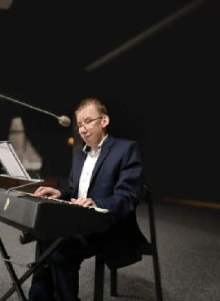 Uczeń naszej szkoły gra na pianie w ramach konkursu muzycznego.