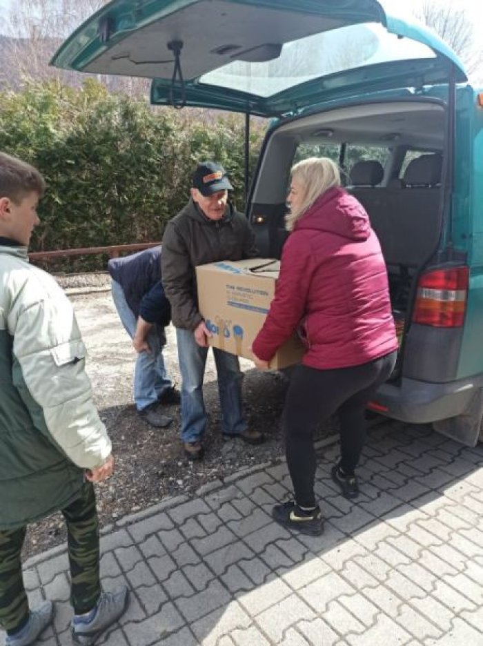 Załadunek zebranych darów dla uchodźców z Ukrainy do busa szkolnego.