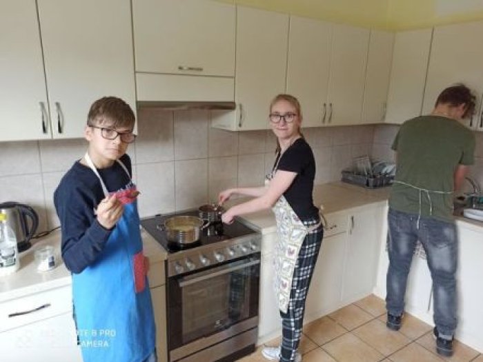 Wychowankowie internatu przygotowują budyń na kuchence elektrycznej.