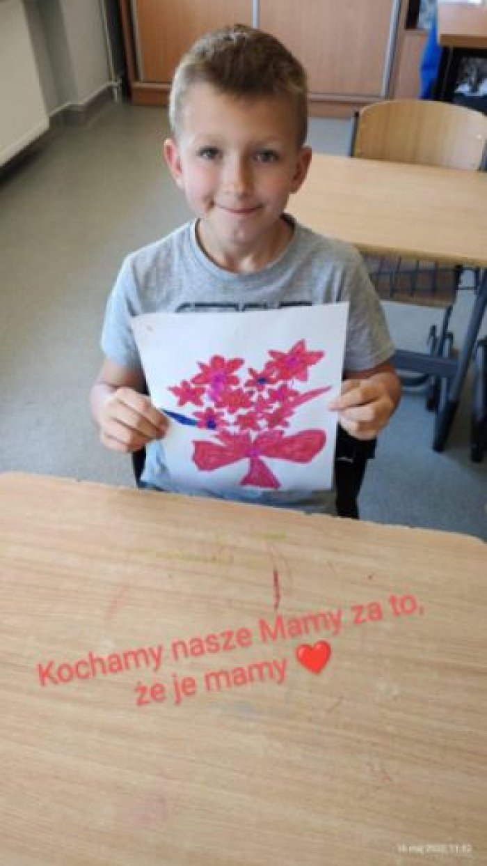 Uczeń prezentuje własnoręcznie wykonaną laurkę.