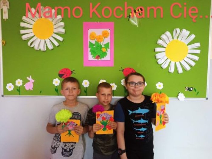 Uczniowie z dumą prezentują wykonane przez siebie laurki dla swojej mamusi.