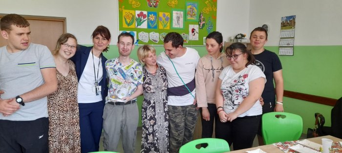 Pamiątkowe zdjęcie solenizanta z uczestnikami przyjęcia urodzinowego.