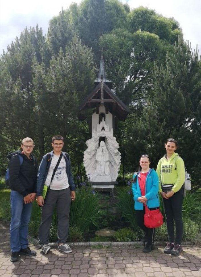 Uczniowie przed figurą Matki bożej Ludźmierskiej.