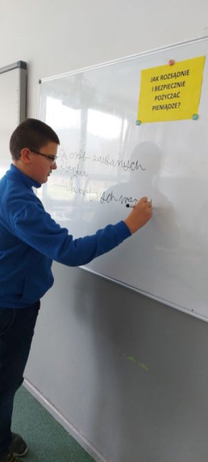 Uczeń redaguje notatkę na temat komu bezpiecznie pożyczać pieniądze.