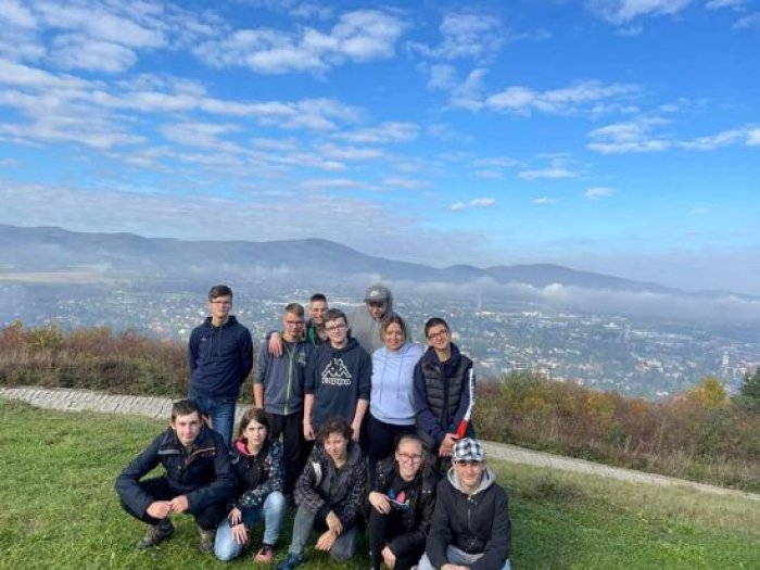 Uczniowie pozują do zdjęcia na tle panoramy miasta Żywiec.