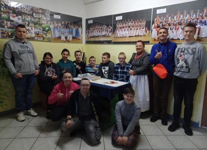 Uczestnicy warsztatów pozują do zdjęcia z Panią Jadwigą Jurasz kierownikiem artystycznym zespołu Grojcowianie.