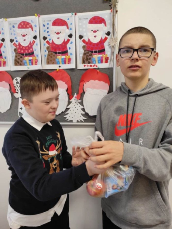 Uczeń wręcza solenizantowi prezent.