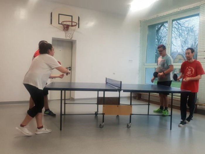 Uczniowie trenują poprawne trzymania rakietki do tenisa stołowego.