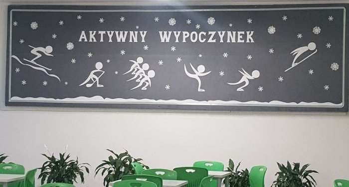 Dekoracja na jadalni szkolnej, przedstawiająca sporty zimowe. 