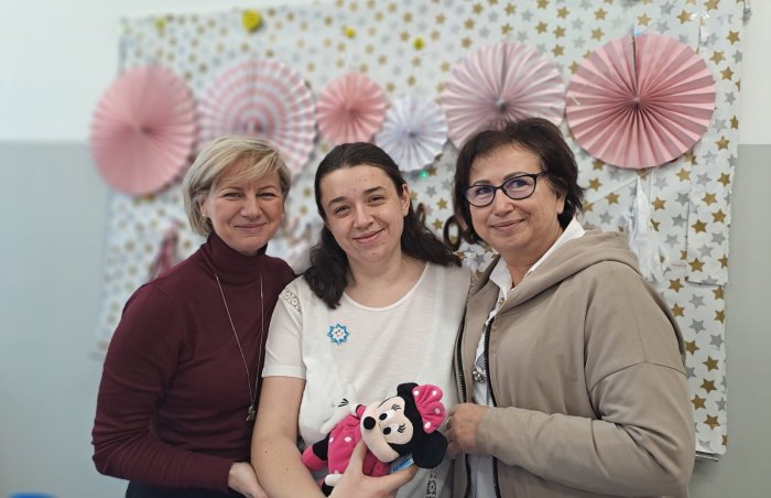 Solenizantka pozuje do zdjęcia z paniami dyrektorkami.
