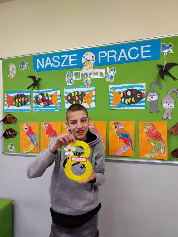 Uczerń prezentuje wykonaną własnoręcznie pracę plastyczną z okazji Dnia Kobiet.