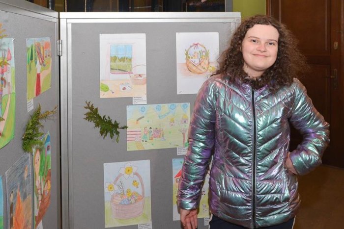 Laureatka Wiktoria i jej praca plastyczna na wystawie w muzeum.