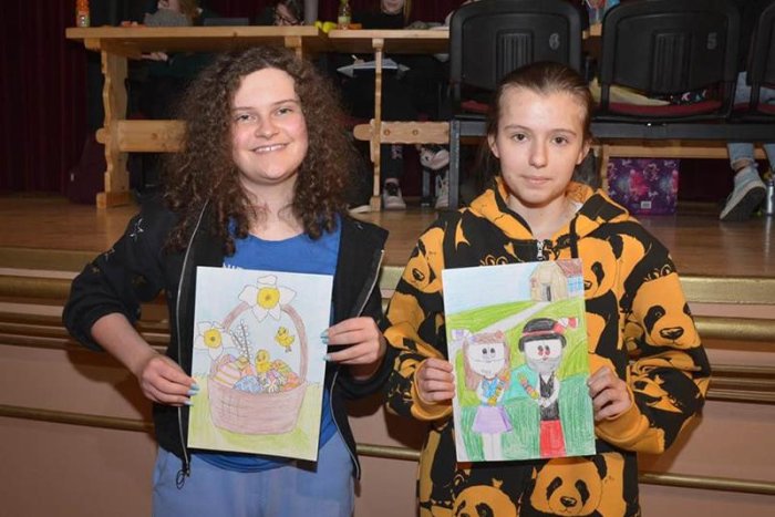 Laureatki konkursu plastycznego prezentują narysowane przez siebie dzieła.