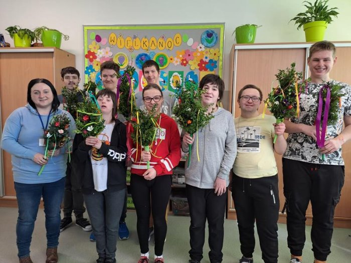 Uczniowie trzymają palmy wielkanocne własnoręcznie wykonane.