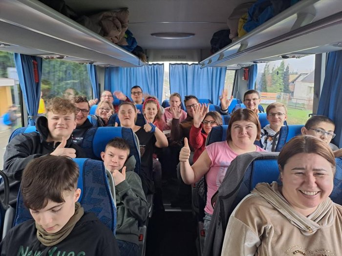Uczniowie szkoły pozują do zdjęcia w autobusie.